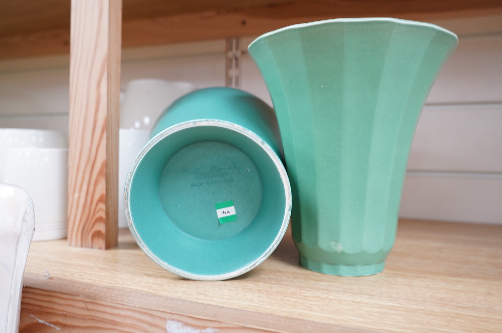 Keith Murray for Wedgwood, two green vases comprising a tapering, fluted example and one with stepped foot, largest 18cm high